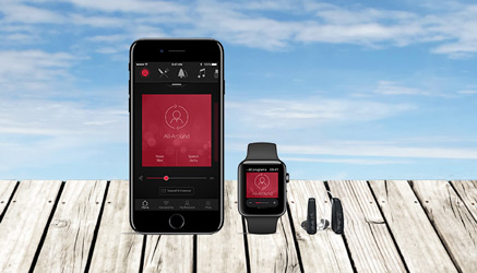 Bild eines Steges, im Hintergrund das Meer. Darauf, von links beginnend, das Hörgerät Resound linx, eine Apple Watch und ein iPhone